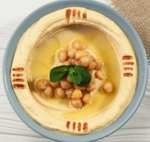 Top view of hummus plate on wooden table